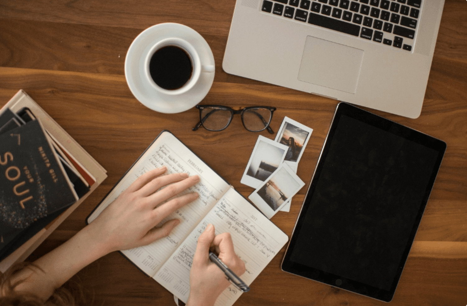 Rustic wooden table with ceramic coffee cup and Hebrew notebook